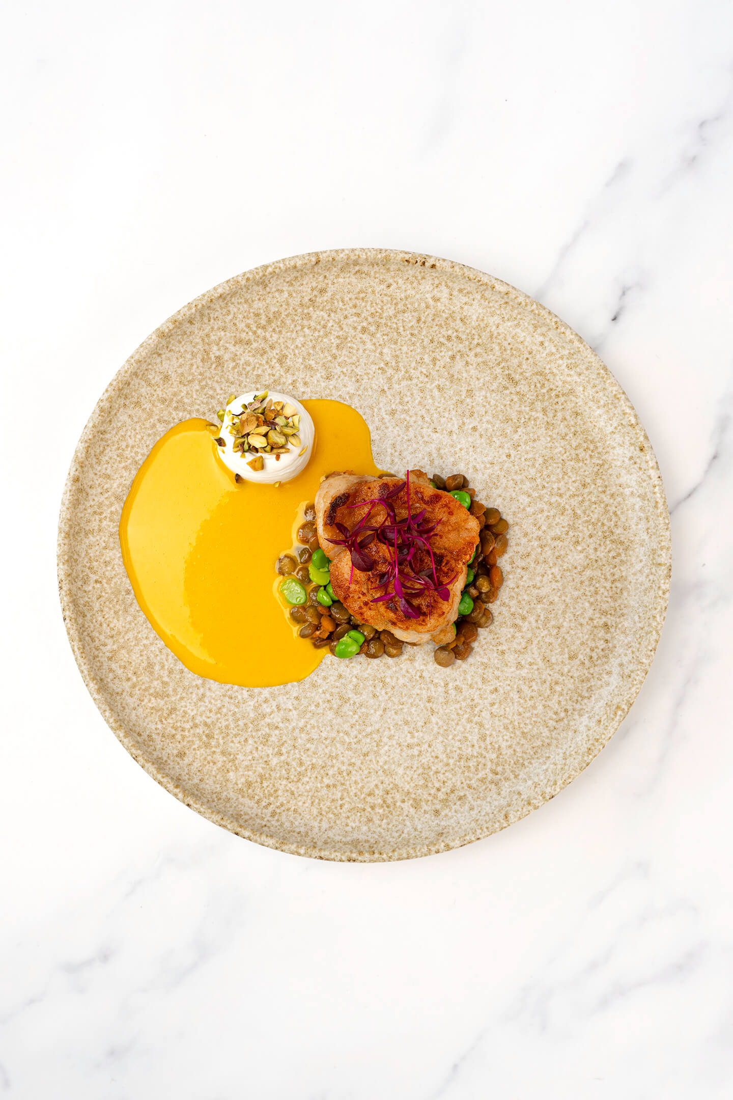 Kalfszwezerik met linzen, vadouvan, geitenyoghurt en een beurre blanc van wortel